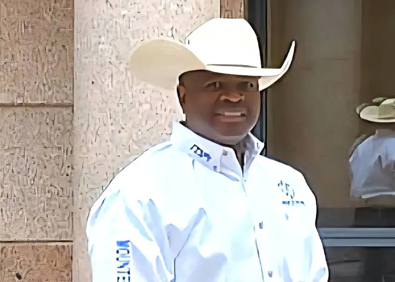A man wearing a cowboy hat and white shirt.