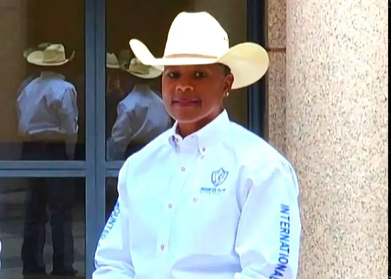 Man wearing a white cowboy hat and white shirt with embroidery.