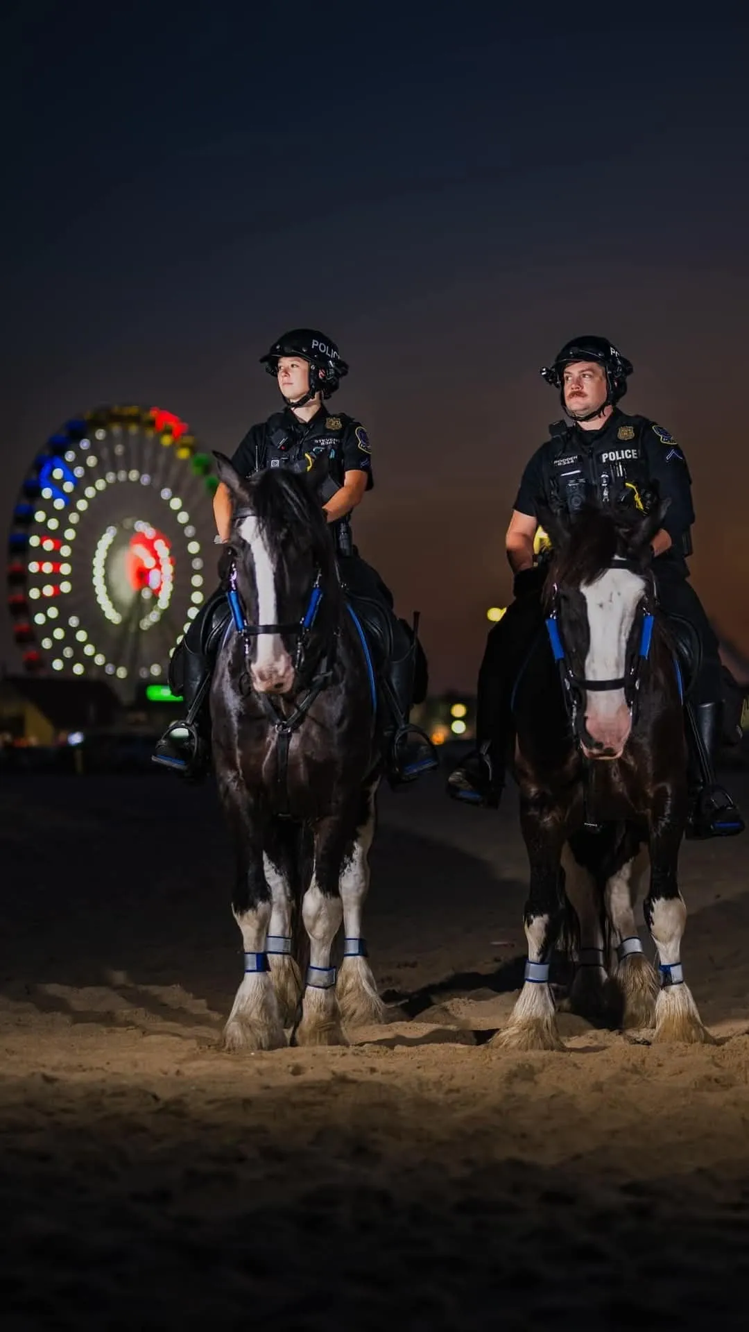 Mounted police officers with Ferris wheel background.